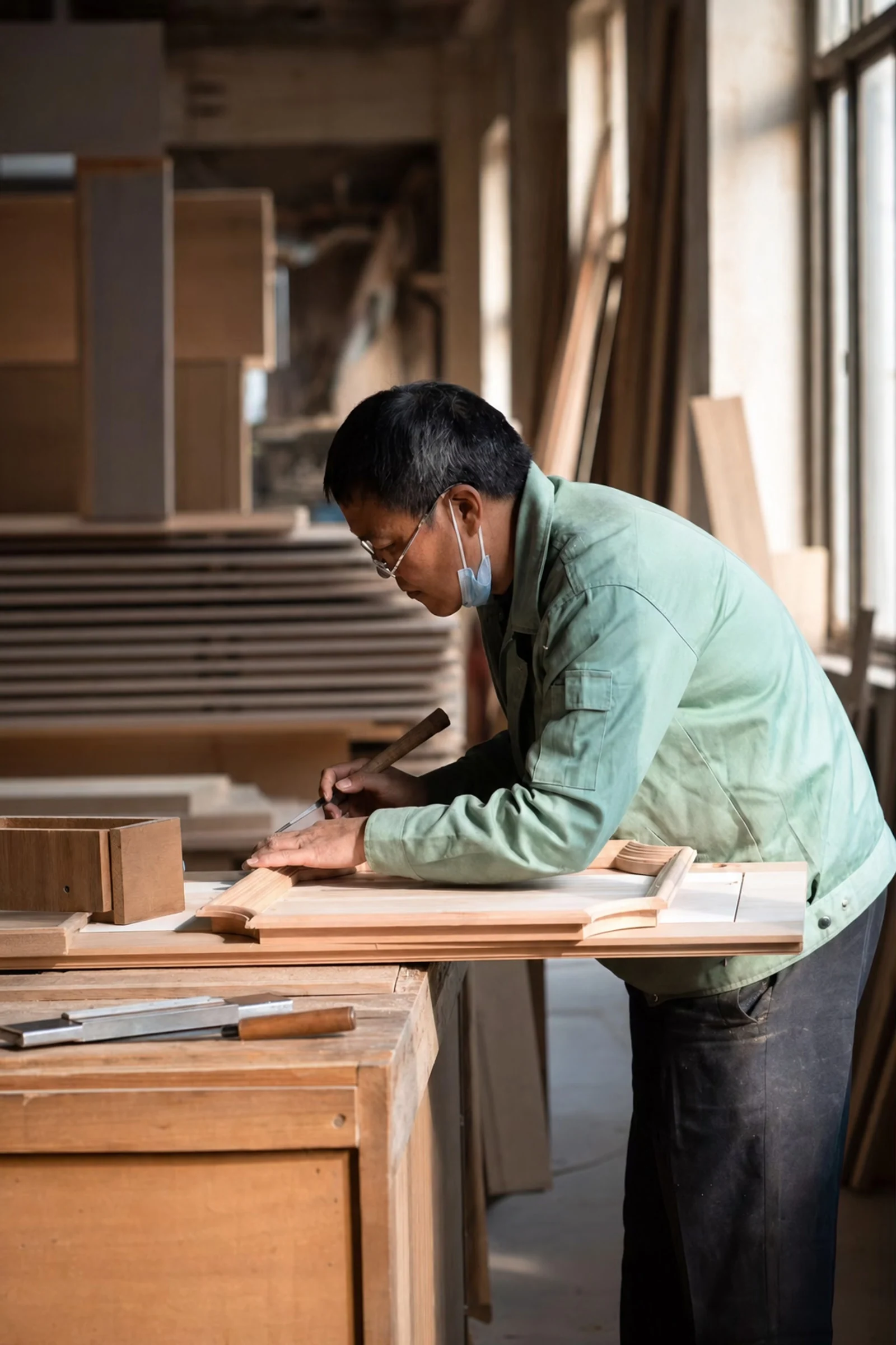 Fenghe craftsperson shaping timber at a workbench